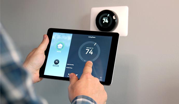 Man is adjusting temperature by using tablet